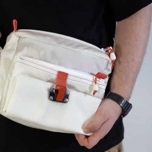 A photo of a person wearing a custom white bag with red pull tabs.