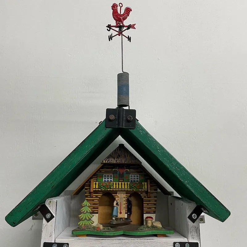 A photo of the green roof of the shrine for weather apointed with a red rooster weather vane